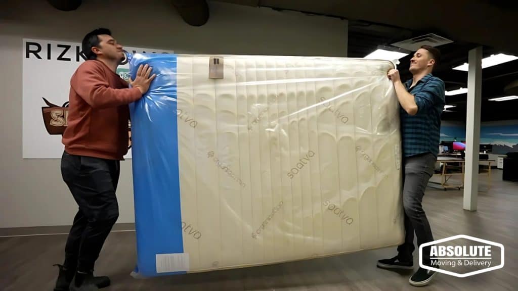 A two movers lifting a large mattress