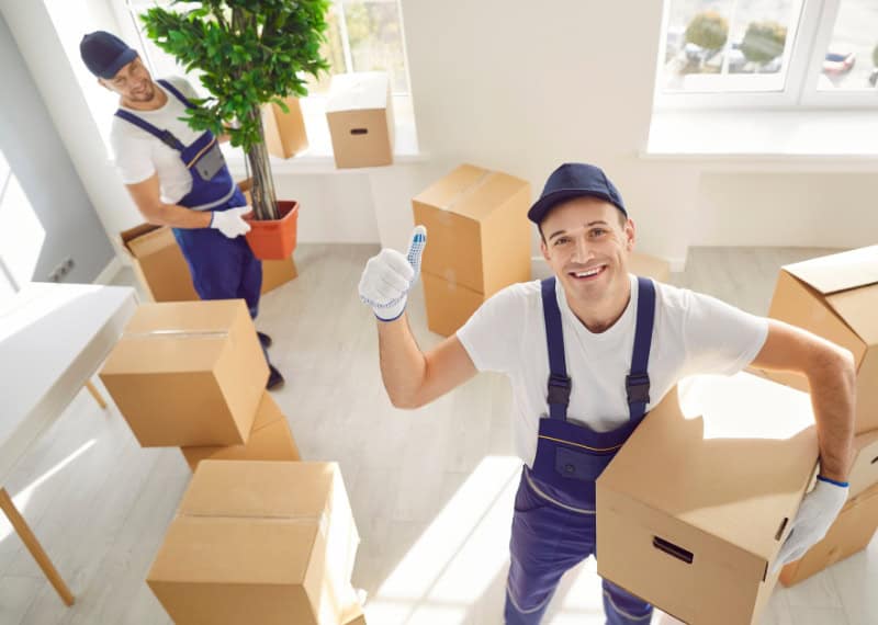 Professional movers handling packing and delivery services in a bright, clean room.
